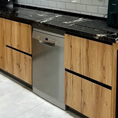 Muebles de cocina en madera con tirador integrado y electrodoméstico panelado