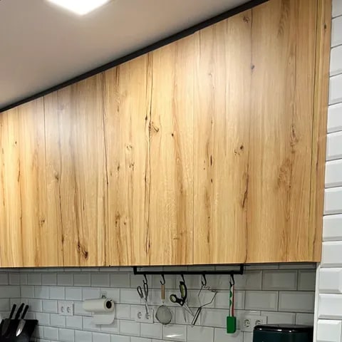Muebles altos de cocina en madera con acabado natural y diseño sin tiradores
