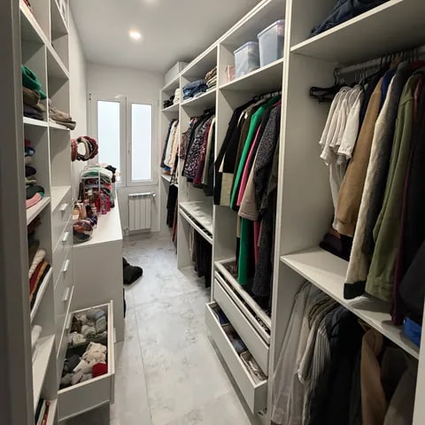 Vestidor abierto a medida con estanterías, cajoneras y zona de colgado